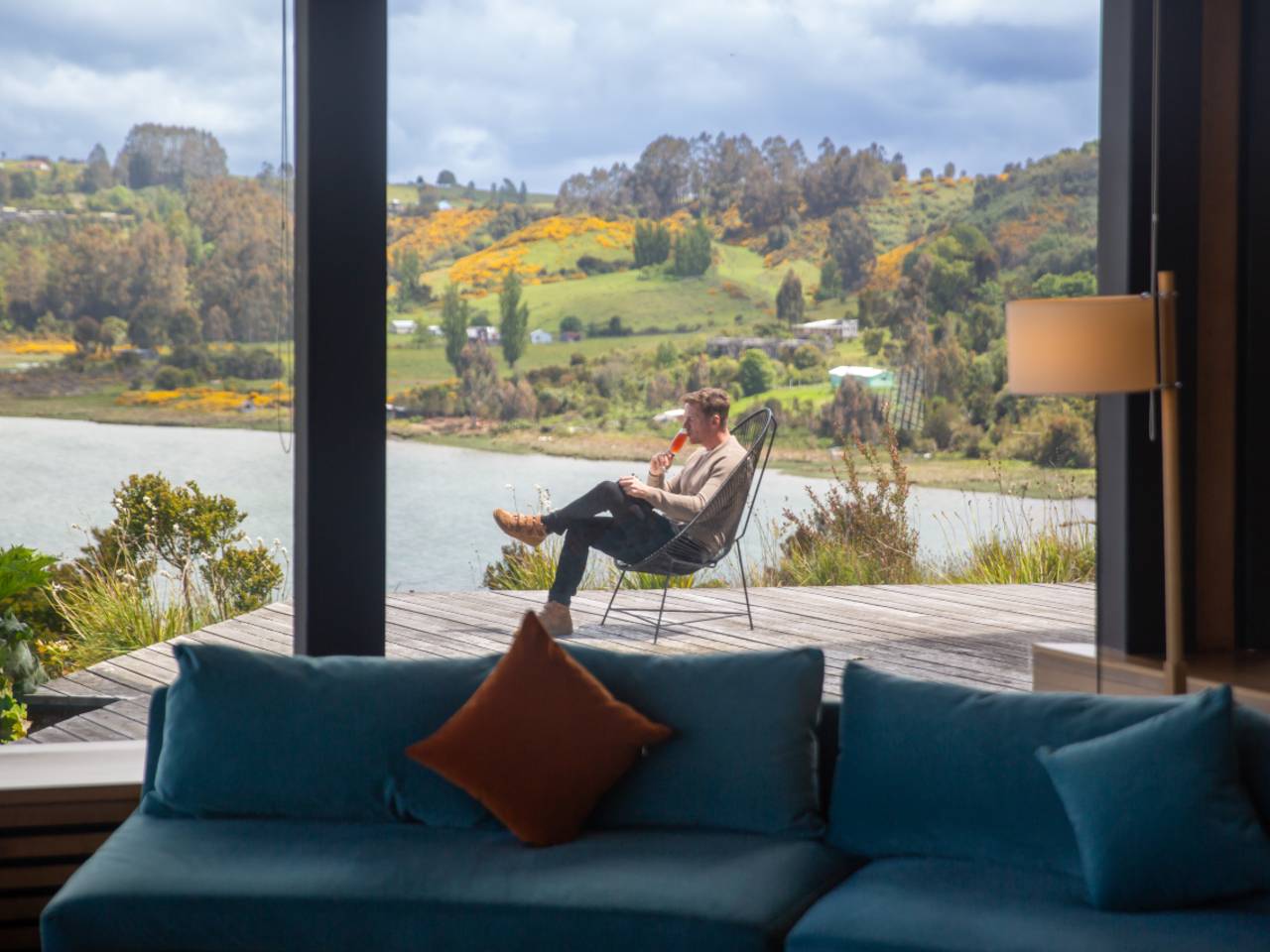 Man drinking on the decking of Refugia Chiloé